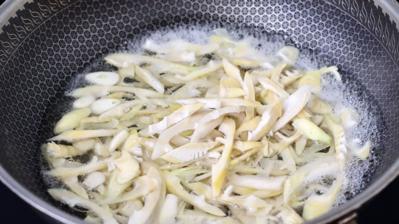 #闹元宵#春日限定的笋片炒肉,锅中倒入适量的清水,放入少许盐烧开,把笋片放入锅中进行绰水。