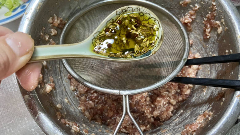 牛肉锅贴➕牛肉芹菜锅贴,再加入两汤匙炸好的香料油,仍然顺着一个方向搅拌吸收。香料油可以增加肉馅的香味和油润,让肉馅香润不柴
