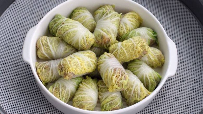 白菜卷肉,将所有菜卷如上图操作完成摆放盘子里,水开上锅大火蒸10-12分钟。