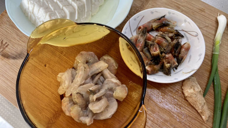 虾仁豆腐煲,虾头虾尾分开,虾头清洗沥水,虾仁剝壳,用刀片开,去除虾线洗净