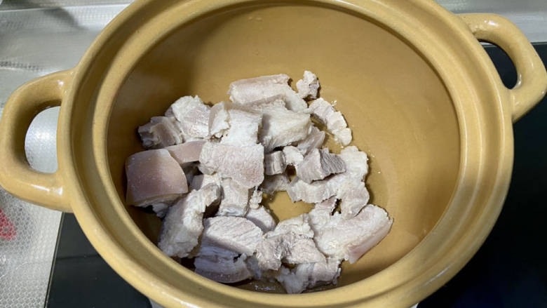 五花肉焖莲藕,砂锅加热后,加少许食用油,下五花肉,小火煎到外皮微焦出油