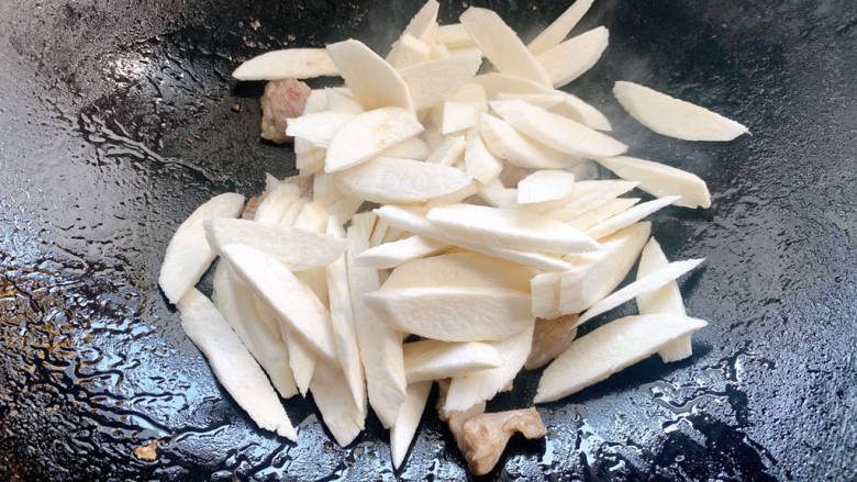 五花肉炒茭白,加入茭白翻炒,并加适量清水焖一下
