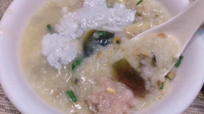 瑶柱蚝豉皮蛋瘦肉粥,用碗盛出,加两片牛乳。