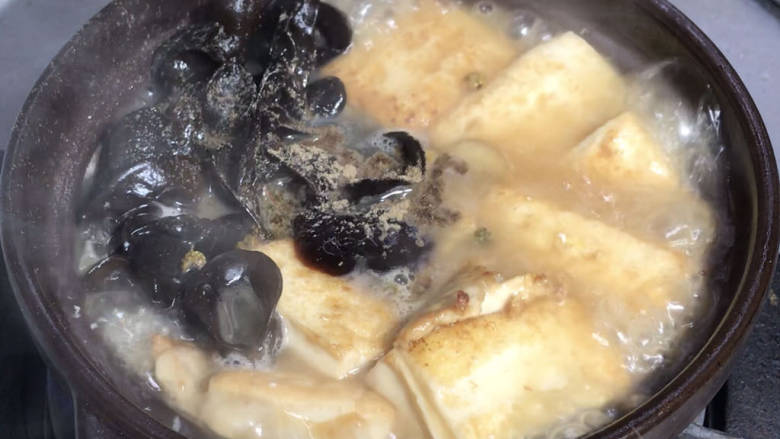 虾仁豆腐煲,放入黑木耳,煮沸后转小火,盖上盖子炖煮10分钟