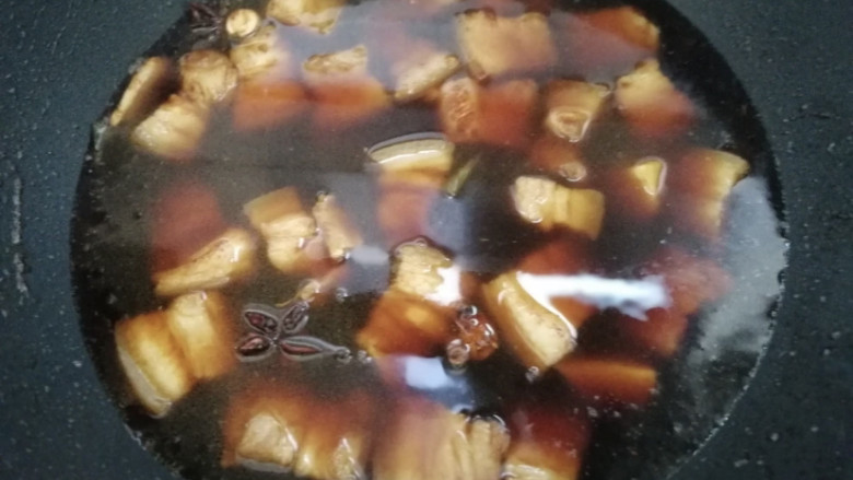 鹌鹑蛋红烧肉,观察五花肉的颜色,比较好看的焦糖色,这时就可以加入开水了。