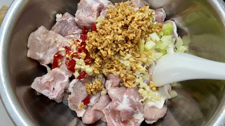 家常蒸排骨➕蒜蓉土豆蒸排骨,把炸好的蒜连同油倒入排骨中,加入剩余的蒜末,姜片,葱白,小米辣